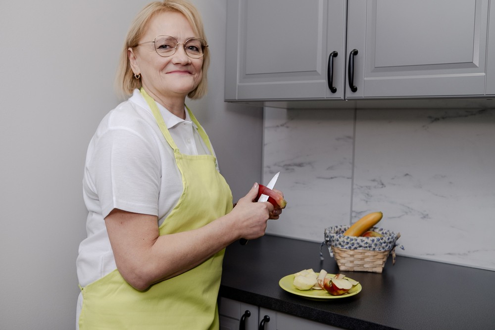 opiekunka przygotowuje posiłek