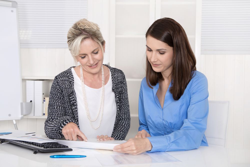 Dwie kobiety omawiające warunki współpracy w biurze